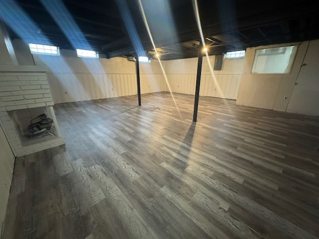 basement featuring dark wood-type flooring and wood walls