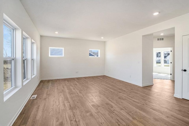 unfurnished room with baseboards, visible vents, wood finished floors, and recessed lighting