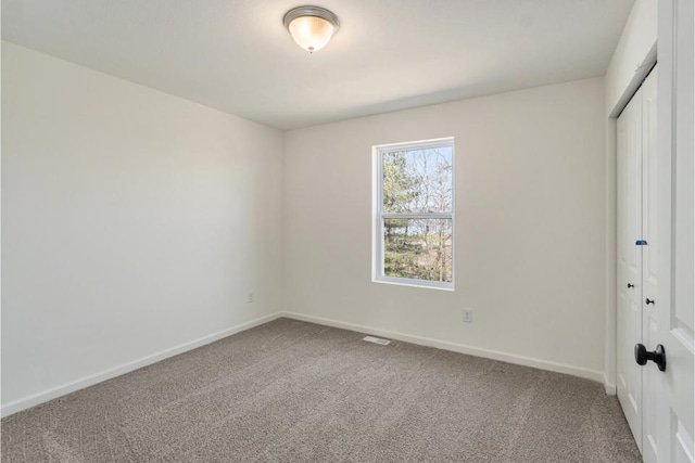 unfurnished bedroom featuring carpet floors, baseboards, and a closet