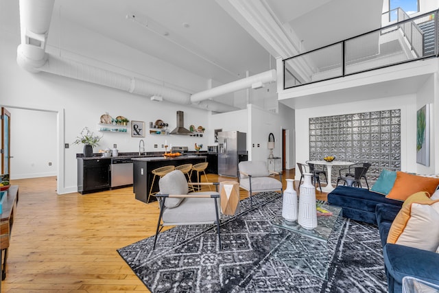 living room featuring hardwood / wood-style floors, sink, and a high ceiling