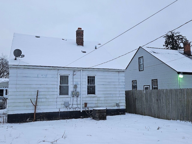 view of snow covered back of property