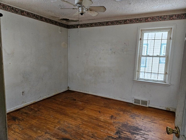 unfurnished room with a healthy amount of sunlight, ceiling fan, dark hardwood / wood-style floors, and a textured ceiling