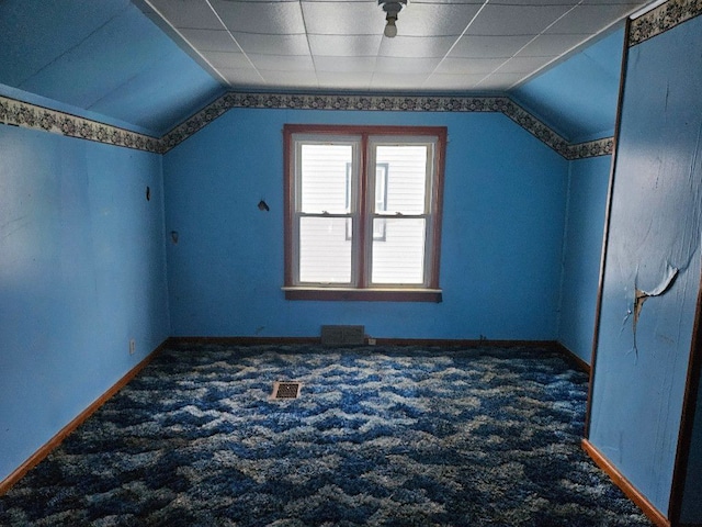 additional living space featuring vaulted ceiling and dark carpet