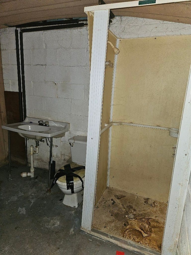 bathroom with sink, concrete floors, and toilet