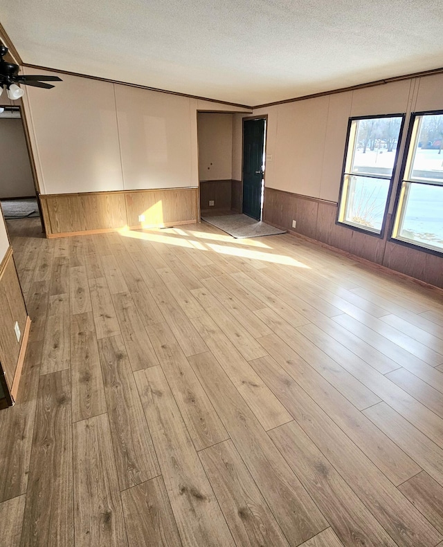 unfurnished room featuring ceiling fan, a textured ceiling, and light hardwood / wood-style floors