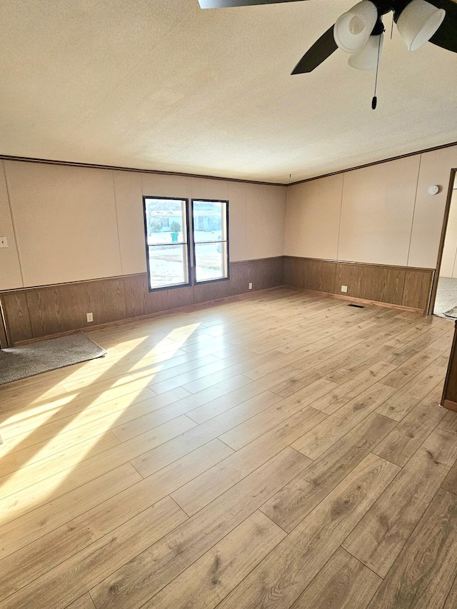 empty room with ceiling fan and light wood-type flooring