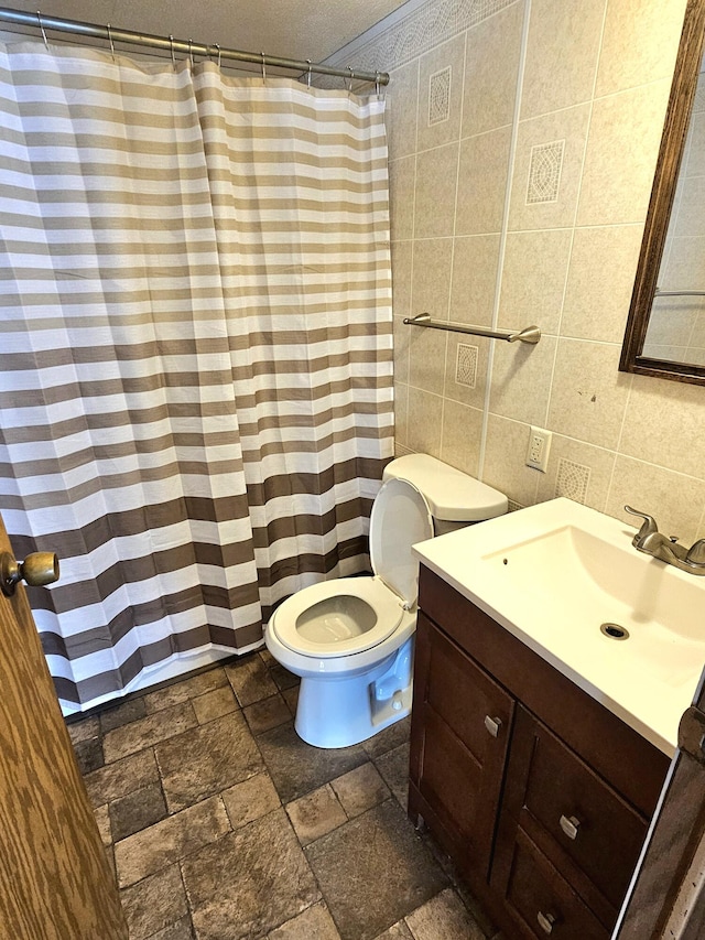 bathroom with toilet, tile walls, a textured ceiling, vanity, and decorative backsplash