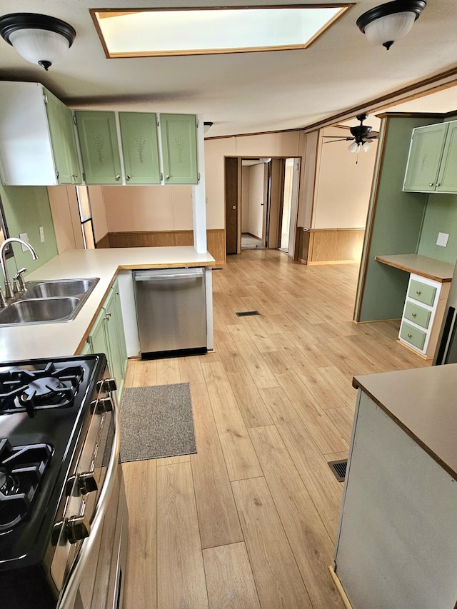 kitchen featuring appliances with stainless steel finishes, sink, green cabinets, and light hardwood / wood-style floors