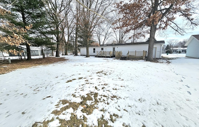 yard layered in snow with a wooden deck