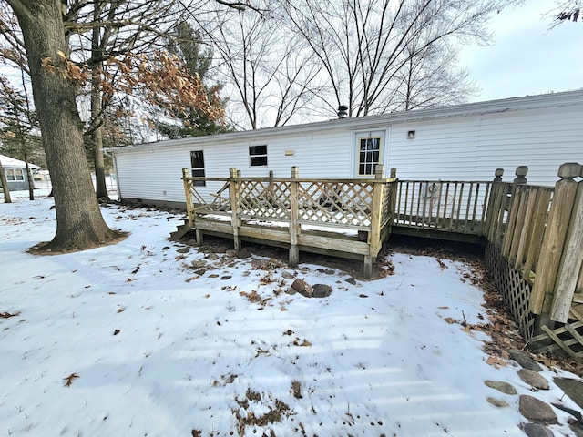 snow covered house featuring a deck