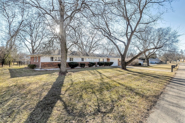 single story home with brick siding, a garage, a front lawn, and fence