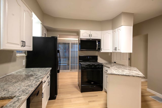 kitchen featuring white cabinetry, light wood-type flooring, light stone counters, and black appliances