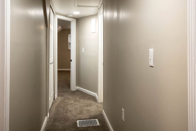 hall with dark colored carpet