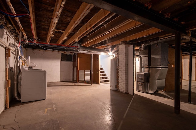 basement with water heater, washer / dryer, and heating unit