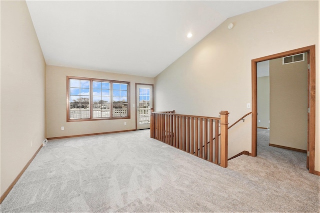 unfurnished room with lofted ceiling and light carpet