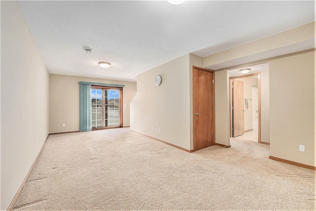 spare room featuring light carpet and a textured ceiling