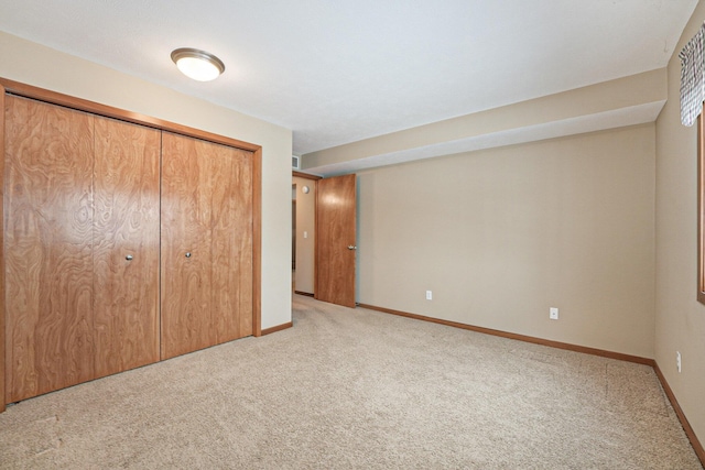 unfurnished bedroom featuring light colored carpet and a closet