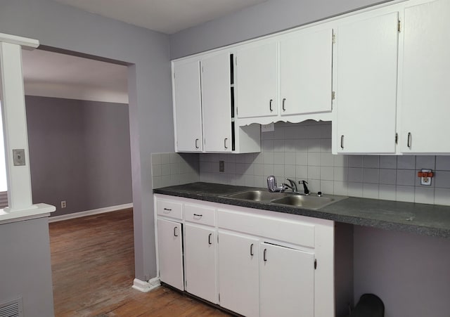 kitchen featuring tasteful backsplash, sink, white cabinets, and dark hardwood / wood-style floors