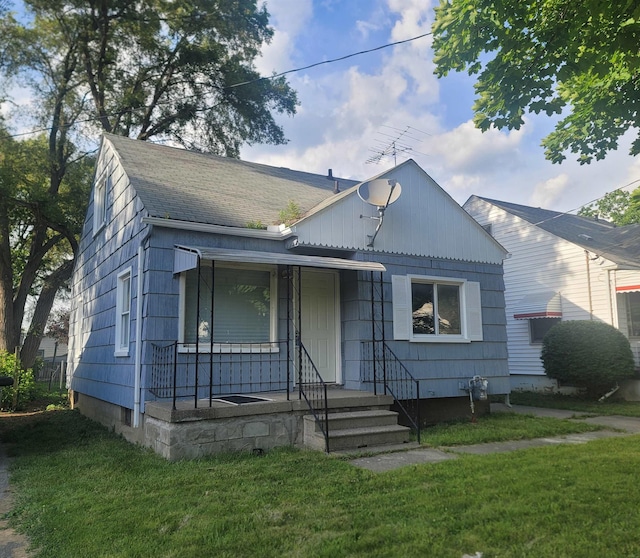 bungalow-style home featuring covered porch and a front lawn