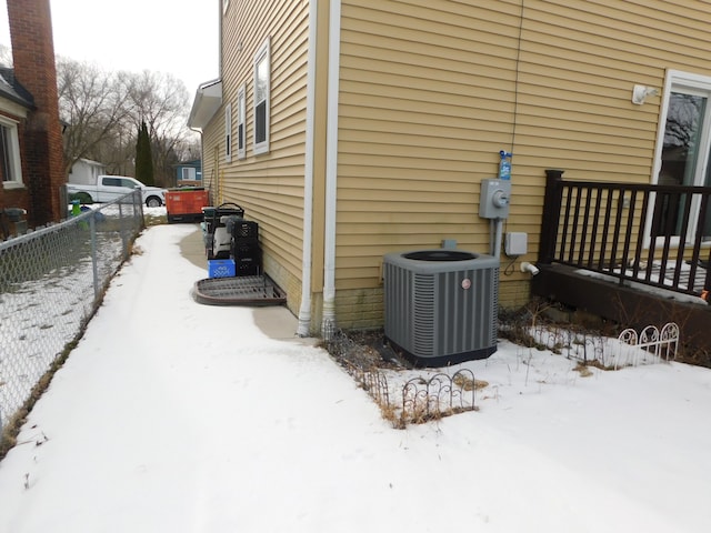 snow covered property with central air condition unit