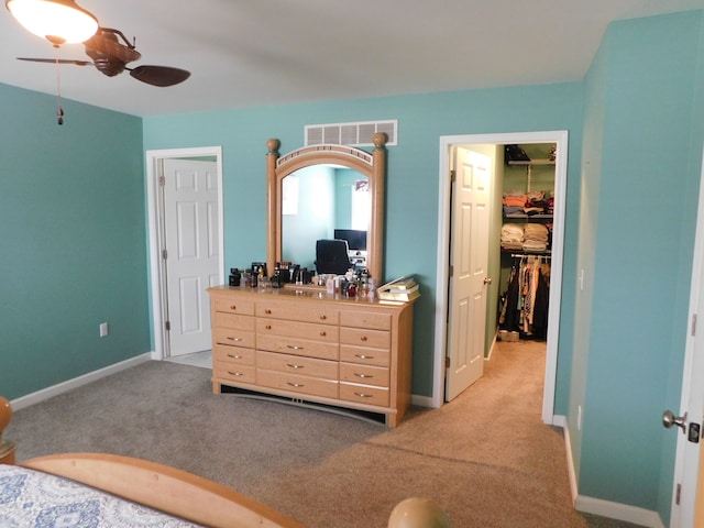 carpeted bedroom featuring ceiling fan and a closet