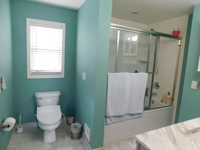 full bathroom featuring vanity, toilet, and combined bath / shower with glass door