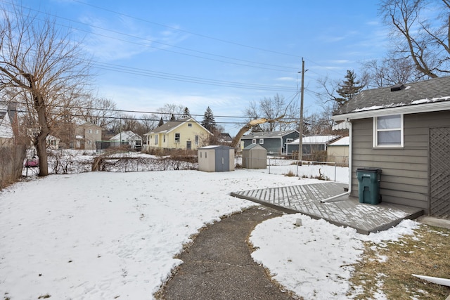 yard covered in snow featuring a storage unit