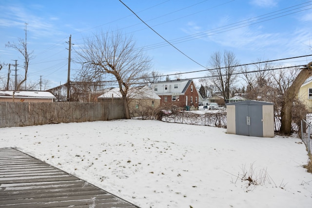 yard covered in snow featuring a shed