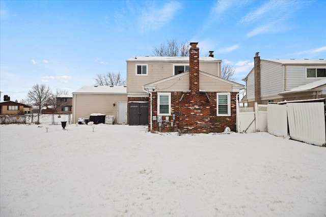 view of snow covered back of property