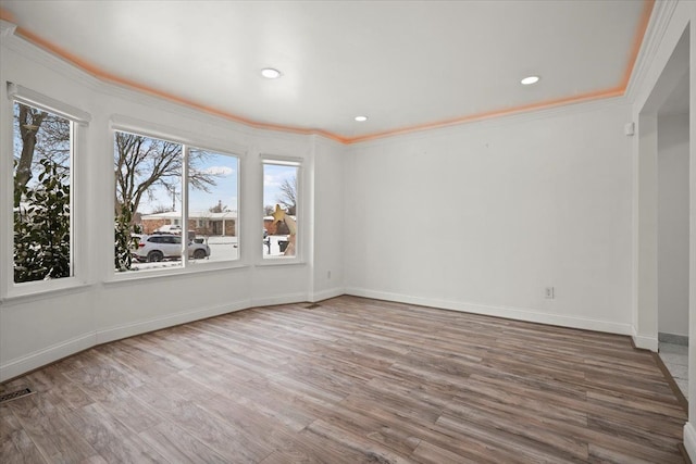 spare room featuring hardwood / wood-style flooring, ornamental molding, and a wealth of natural light