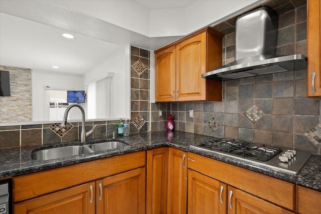 kitchen with sink, dark stone counters, decorative backsplash, stainless steel gas cooktop, and wall chimney exhaust hood