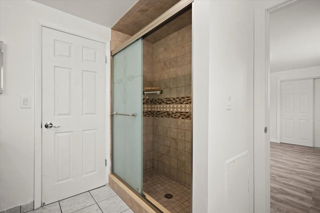 bathroom with an enclosed shower and tile patterned flooring