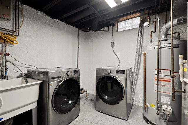 laundry room with washing machine and clothes dryer, sink, and gas water heater