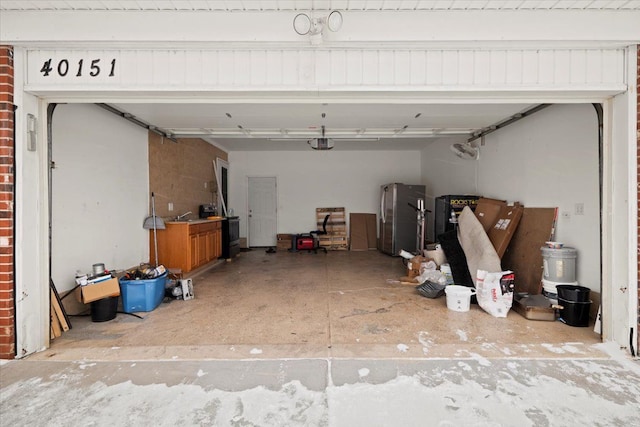 garage featuring a garage door opener and stainless steel refrigerator