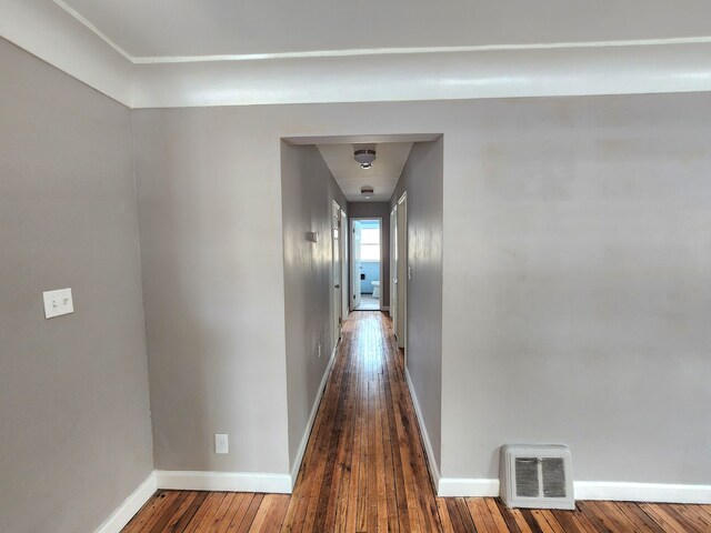 hallway featuring baseboards and hardwood / wood-style flooring