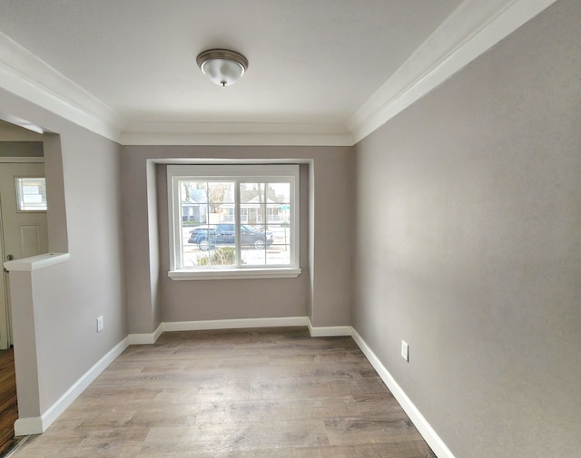 unfurnished room featuring ornamental molding and light wood-type flooring