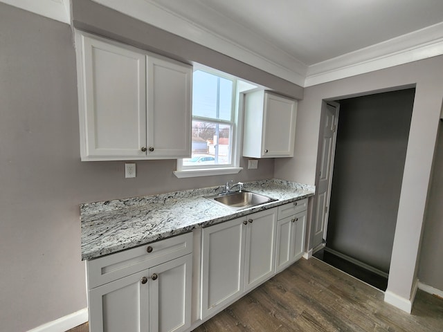 kitchen with dark wood-type flooring, sink, white cabinetry, ornamental molding, and light stone countertops