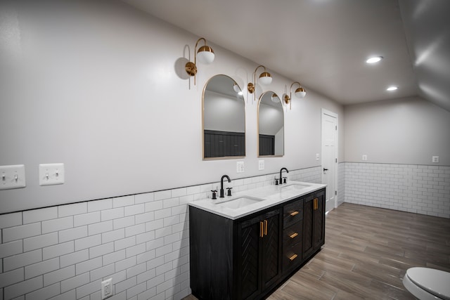 bathroom featuring vanity, wood-type flooring, tile walls, and toilet