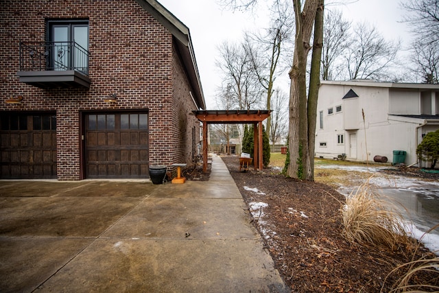 view of side of home with a garage and a balcony