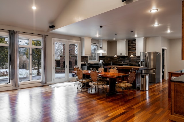 dining space featuring lofted ceiling and dark hardwood / wood-style floors