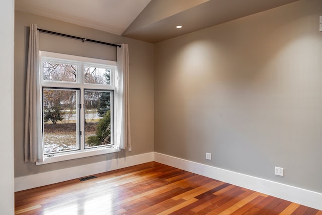 unfurnished room with lofted ceiling and light wood-type flooring