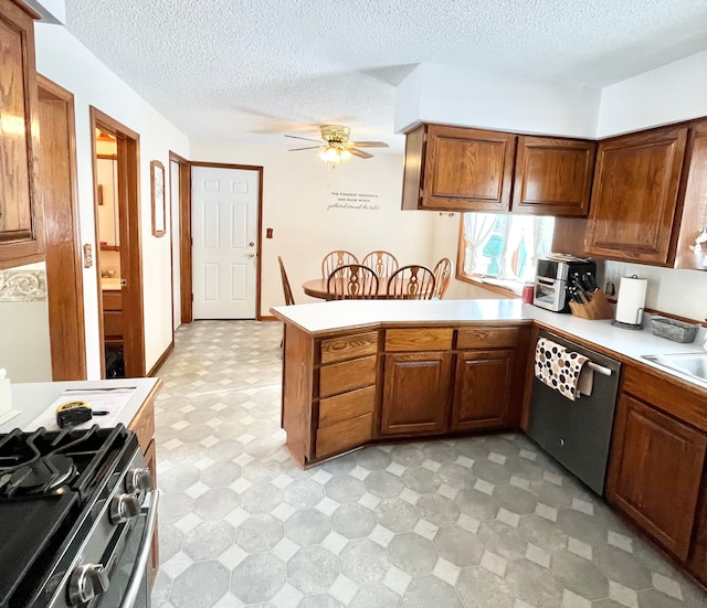 kitchen with sink, a textured ceiling, appliances with stainless steel finishes, kitchen peninsula, and ceiling fan