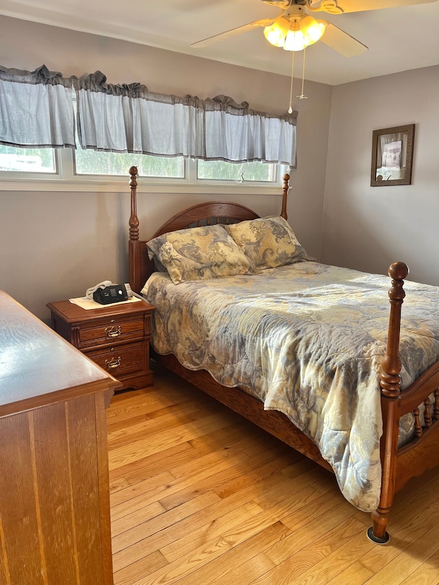 bedroom featuring multiple windows, light hardwood / wood-style flooring, and ceiling fan