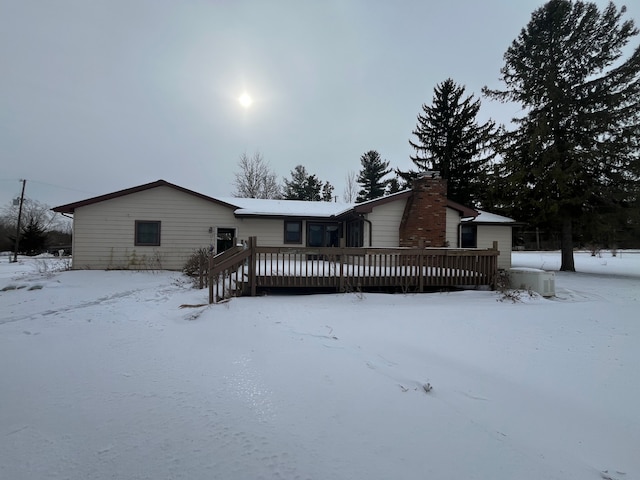 snow covered house with a deck