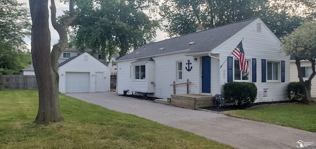 view of front of property featuring an outbuilding, a garage, and a front lawn