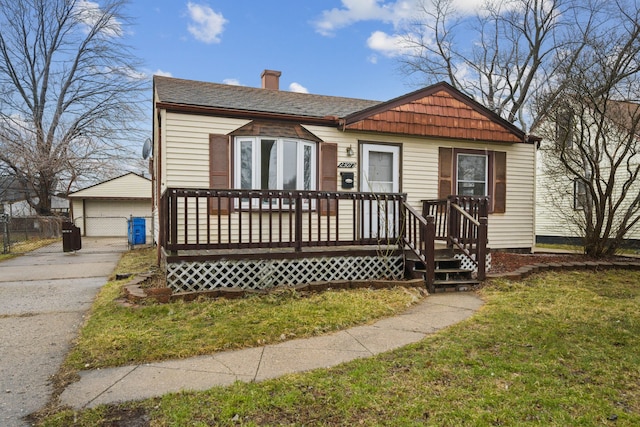 view of front of house featuring an outbuilding, a garage, and a front yard