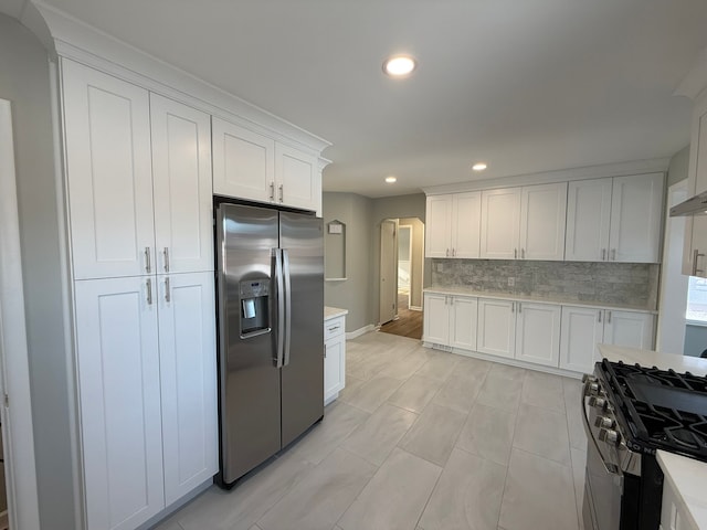 kitchen featuring tasteful backsplash, stainless steel fridge, white cabinets, and black gas stove