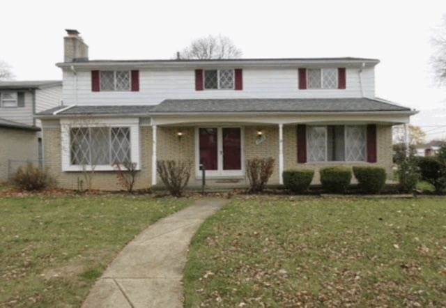 traditional home featuring a chimney and a front yard