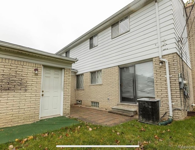 rear view of property with entry steps, a patio, brick siding, and central air condition unit