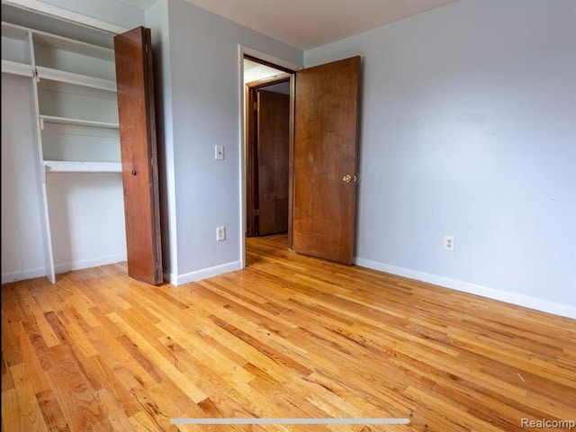 unfurnished bedroom featuring a closet and light hardwood / wood-style flooring